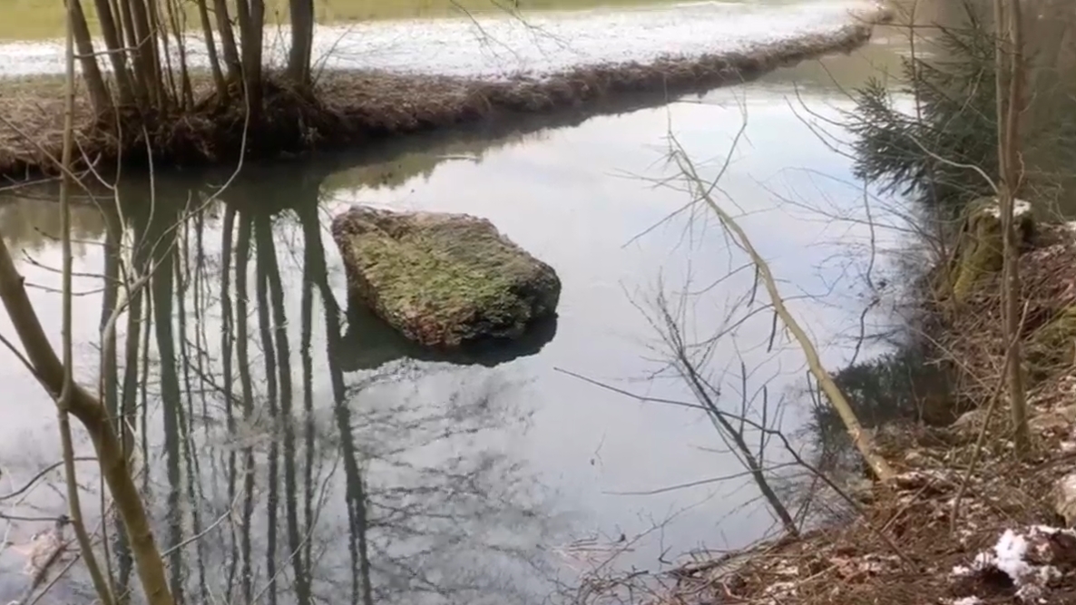 Das Bild zeigt einen Fels in einem Fluss der aus einer Kletterwand ausgebrochen ist